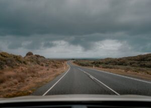 picture of road going throug a valley with dark ominous clouds